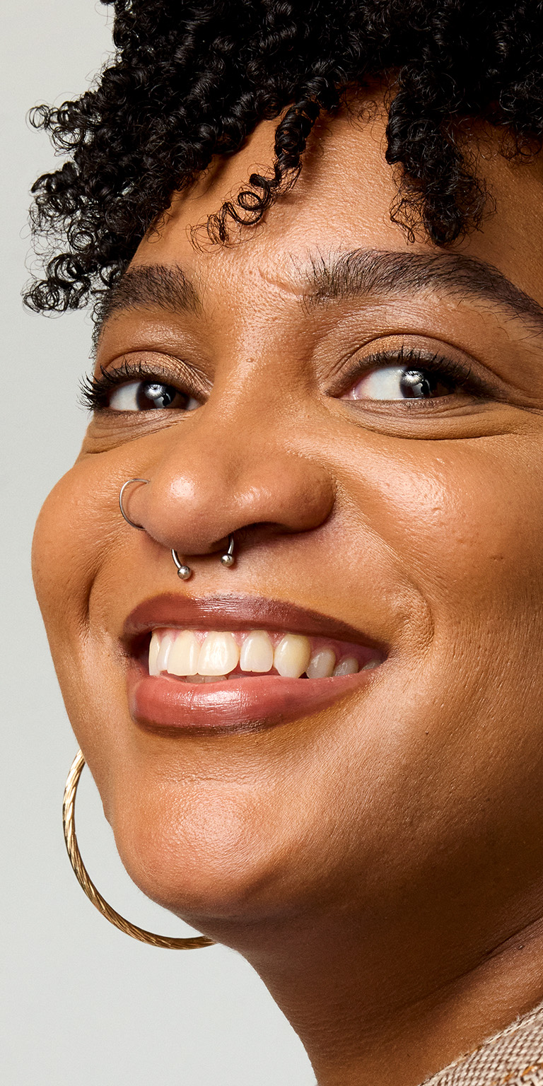 Vista de perfil de una mujer sonriendo a la c&aacute;mara